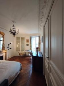 1 dormitorio con 1 cama, 1 mesa y 1 silla en Chambre spacieuse - Trocadéro, en París