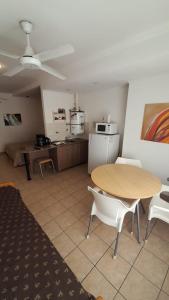 sala de estar con mesa y cocina en Apartamentos Güemes - Monoambientes en Bahía Blanca