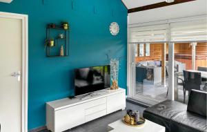 sala de estar con TV en una pared azul en Oud Kempen Bungalow 181 en Stavenisse