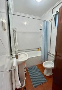 uma casa de banho branca com um lavatório e um WC em Portuguese village apartment - Casa Martins No.54 em Freiria