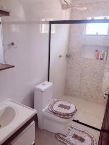 a bathroom with a shower and a toilet and a sink at Alugo casa para Show Rural in São Domingos