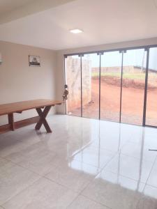 an empty room with a wooden table and glass doors at Alugo casa para Show Rural in São Domingos