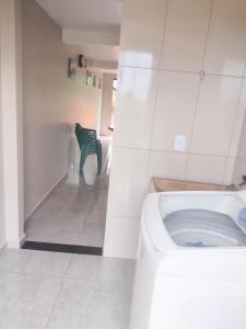 a bathroom with a toilet and a green chair at Alugo casa para Show Rural in São Domingos