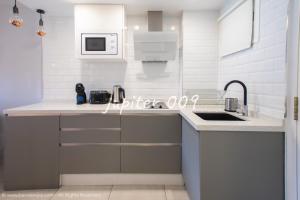 a white kitchen with a sink and a microwave at J009 - Studio - Complex Minerva & Jupiter in Benalmádena