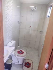 a white bathroom with a toilet and a sink at Alugo casa para Show Rural in São Domingos