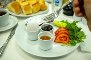 a plate of food with eggs and fruit on a table at BECANLAR OTEL in Yalova