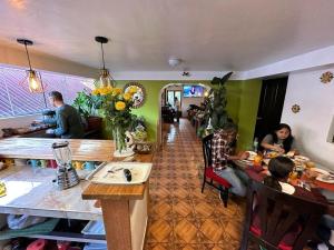 un gruppo di persone seduti ai tavoli in un ristorante di Parwa Guest House a Ollantaytambo