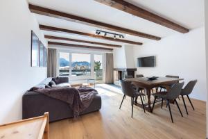 a living room with a bed and a table and chairs at Modern crossing apartment facing Piz Rosatsch in St. Moritz