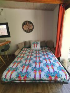 Bett in einem Zimmer mit farbenfroher Bettdecke in der Unterkunft Mini Villa Giuseppina in Bonifacio