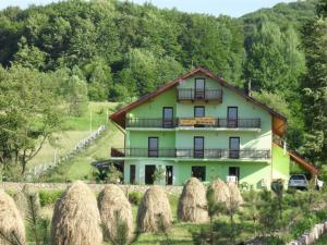 a large house with hay bales in front of it at Grandemi Belvedere Bucovina in Frasin