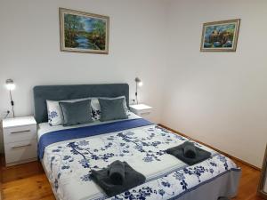 ein Schlafzimmer mit einem Bett mit zwei Hüten darauf in der Unterkunft Entire house floor - 2-Bedroom Cozy & Peaceful Apartment in Podgorica