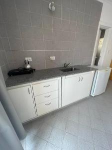 a kitchen with a sink and a white refrigerator at Verona Hostel in Necochea