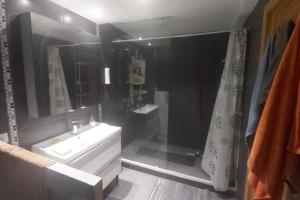 La salle de bains est pourvue d'un lavabo blanc et d'une douche. dans l'établissement Holikeys - Agadir - 2 Ch - El Houda 001, à Agadir
