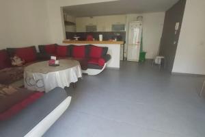 - un salon avec un canapé rouge et une table dans l'établissement Holikeys - Agadir - 2 Ch - El Houda 001, à Agadir