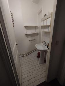 a white bathroom with a sink and a toilet at Chambre spacieuse - Trocadéro in Paris