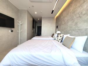 Elliy's Room في بوسان: غرفة نوم بسريرين وتلفزيون بشاشة مسطحة