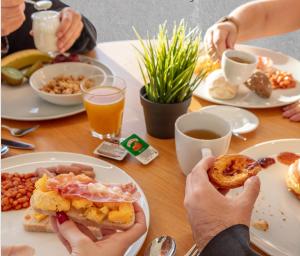 a table with plates of breakfast foods and drinks at Stay Hotel Faro Centro in Faro
