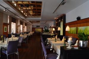 une salle à manger avec des tables et des chaises blanches dans l'établissement Hotel Schwert, à Rastatt