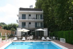 una piscina con sillas y sombrillas junto a un edificio en Hotel L'Ast, en Banyoles