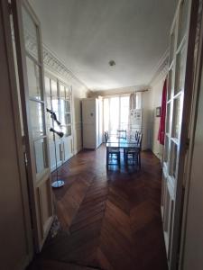 Chambre spacieuse - Trocadéro في باريس: ممر مع طاولة وكراسي في غرفة