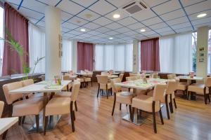 a dining room with white tables and chairs at Brit Hotel Lille Centre in Lille