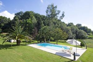 una piscina en un patio con sombrilla en Villa Fortune - 11 couchages - Piscine & Tennis, en Bayona