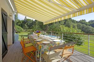 una mesa de comedor en una terraza con sillas en Villa Fortune - 11 couchages - Piscine & Tennis, en Bayona
