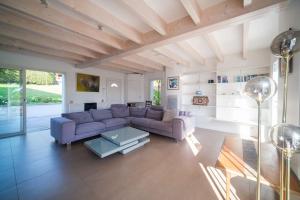 sala de estar con sofá púrpura y mesa en Villa Fortune - 11 couchages - Piscine & Tennis, en Bayona