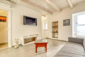 a living room with a couch and a tv on the wall at Casa Le Fonti Casa vacanze in Osimo