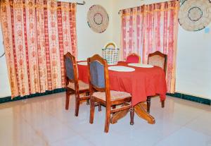 comedor con mesa roja y sillas en CAJANUS RESORT KARATU, en Karatu