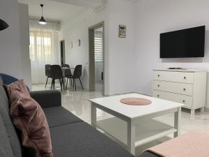 uma sala de estar com um sofá e uma mesa em Luxury Lazar Towers by GLAM Story em Iaşi