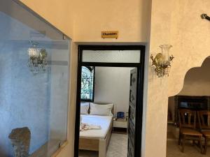 RIAD REDWAN في مراكش: غرفة نوم مع سرير وغرفة مع مرآة