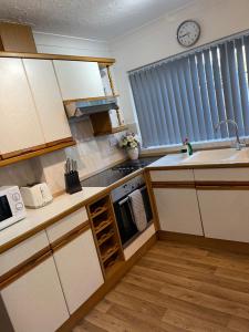 a small kitchen with a sink and a stove at Peaceful 3 Bed Home in Basildon