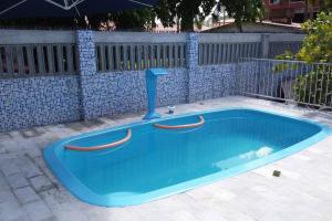 a blue swimming pool with a paddle in it at Casa com Piscina em Itamaracá in Itamaracá