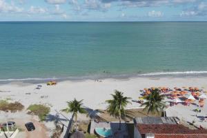 伊塔馬拉卡的住宿－Casa com Piscina em Itamaracá，享有海滩的空中景致,配有遮阳伞和海洋