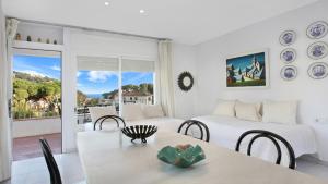 a living room with two beds and a table and chairs at 1Pand02 in Llafranc