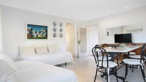 a white living room with a table and a couch at 1Pand02 in Llafranc