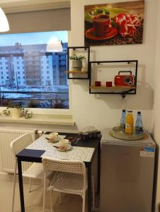 eine Küche mit Tisch und Stühlen und einem Fenster in der Unterkunft Apartament Gardena Olsztyn in Olsztyn + 8 Fotos