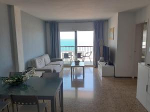 sala de estar con sofá y mesa en Suitur apartamento primera linea mar vistas playa, en Canet de Mar