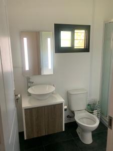 La salle de bains est pourvue de toilettes, d'un lavabo et d'une fenêtre. dans l'établissement PIRIA, à Playa Hermosa
