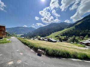 an empty road in a village with mountains in the background at 3 Fontaines - Apt C1 - BO Immobilier in Châtel