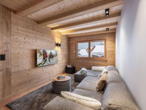 a living room with a couch and a tv at 3 Fontaines - Apt C1 - BO Immobilier in Châtel