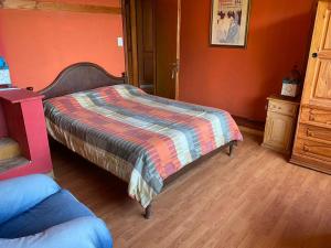 Un dormitorio con una cama con una manta de colores. en Del Francés en Villa La Angostura