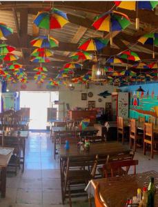 un restaurante con sombrillas coloridas colgando del techo en Pousada Porto Marola, en Porto de Galinhas