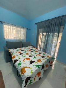 1 dormitorio con cama con edredón en Nuestro airbnb, en San Felipe de Puerto Plata