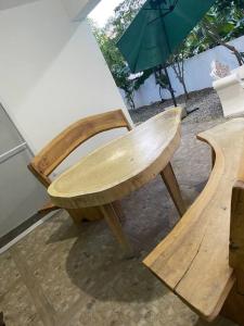 una silla de madera sentada junto a una mesa con sombrilla en Nuestro airbnb, en San Felipe de Puerto Plata