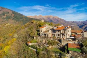 ein Haus auf einem Hügel mit Bergen im Hintergrund in der Unterkunft Vivi Luxury Country House in Comano