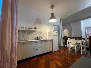 a kitchen with a white refrigerator and a table and chairs at Garden suite / del ducato in Parma