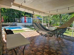 um pátio com uma rede de descanso e uma piscina em oasis with pool near Panama Canal na Cidade do Panamá