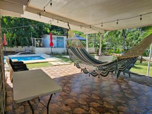 a patio with a hammock and a swimming pool at oasis with pool near Panama Canal in Panama City